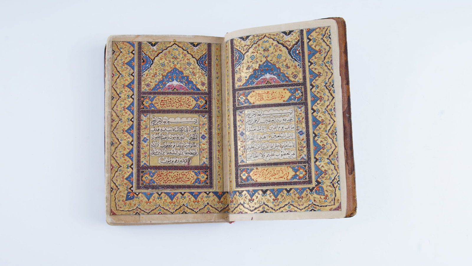 AN EXCEPTIONAL 19TH CENTURY QAJAR MANUSCRIPT QUR’AN WITH LACQUER BINDING AND GOLD-ILLUMINATED: An exceptional Arabic manuscript Qur’an on paper, comprising 221 leaves, each folio with 18 lines of elegant black Naskh script. Diacritics and vowel points are highlighted in red, with marginal ann