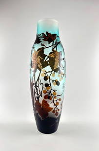 Emile Gallé Acid Etched Cameo Glass Vase with Vine Motif: A tall, vari-colored cameo glass vase in the style of Émile Gallé, featuring an applied intricate vine and leaf motif in brown and golden tones against a frosted blue background. The vase is signed