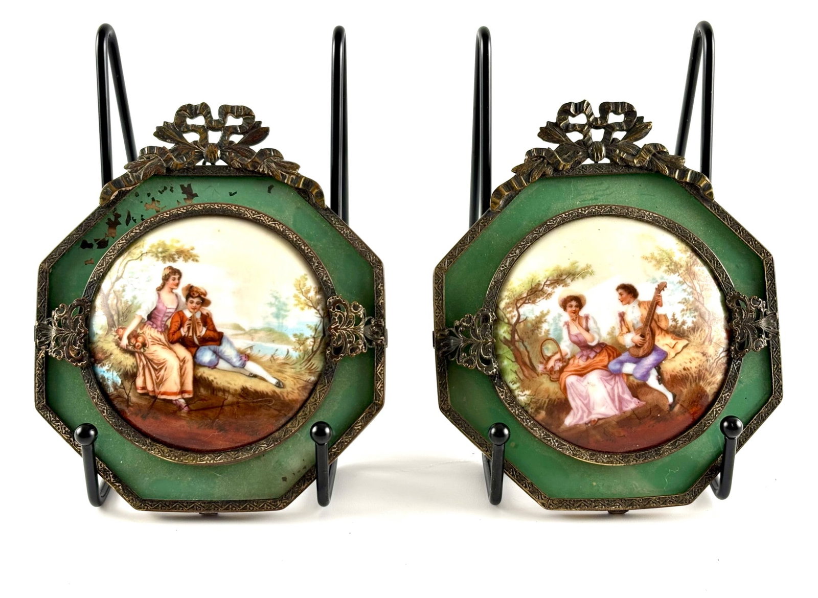 Framed Hand-Painted Porcelain Plaques with Romantic Scenes: Octagonal porcelain plaques featuring hand-painted romantic pastoral scenes with male musicians and female figures. Each plaque is set in a green surround with intricate gilt metal mounts, including f