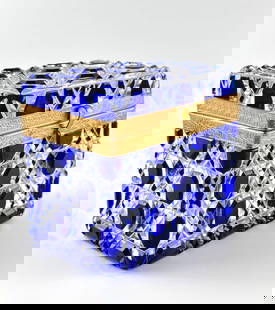 Bohemian Cut Crystal and Gilt Casket Box: Rectangular Bohemian cut crystal casket featuring cobalt blue and clear faceted panels in geometric motifs. The lid and the base are joined by a gilt brass mount with intricate foliate engraving. The