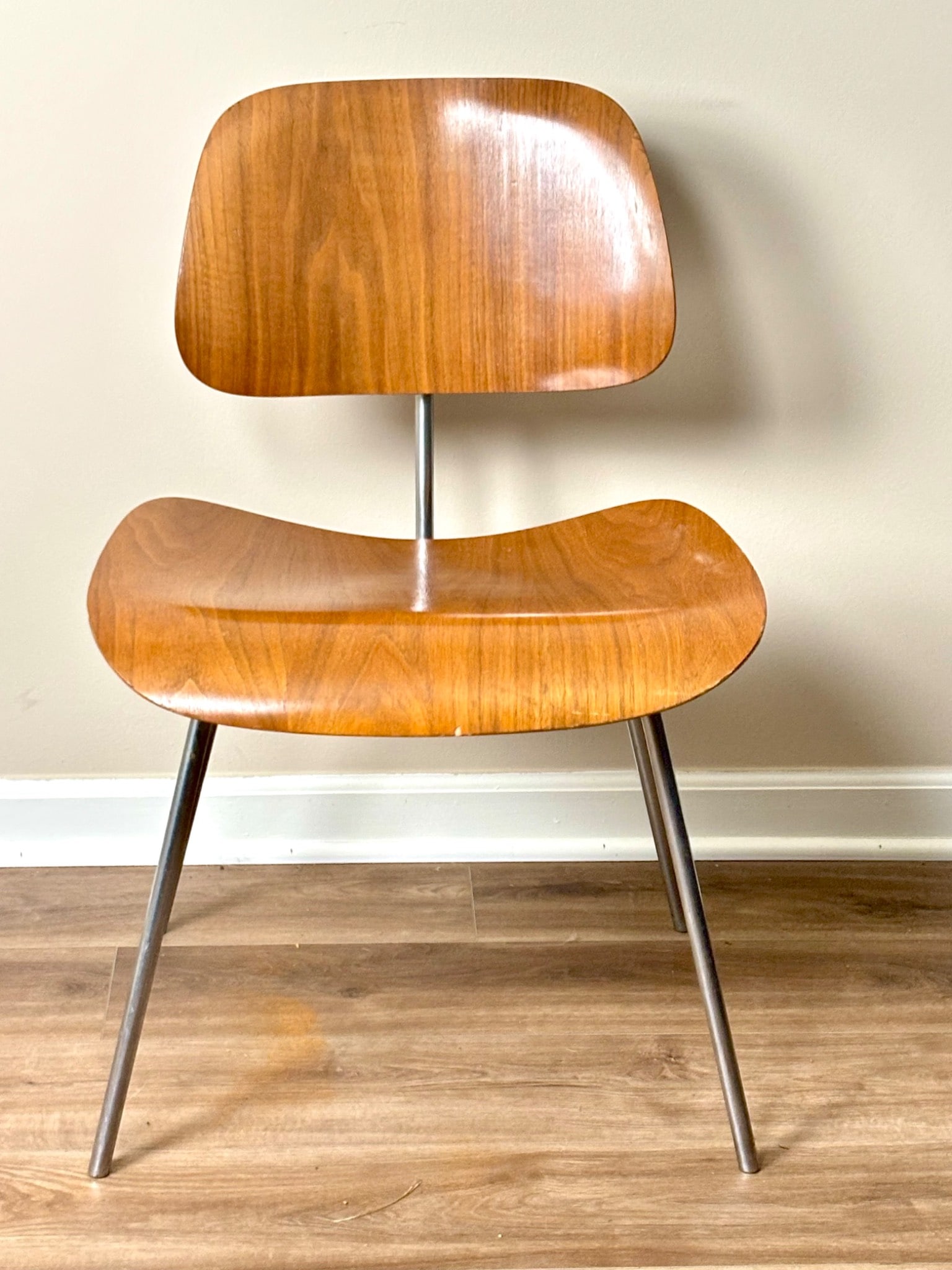 Herman Miller Eames Molded Plywood Chair with Metal Base: Herman Miller Eames molded plywood chair designed by Charles Eames, featuring a curved plywood backrest and seat supported by a tubular metal base. The plywood displays a natural wood veneer finish, a