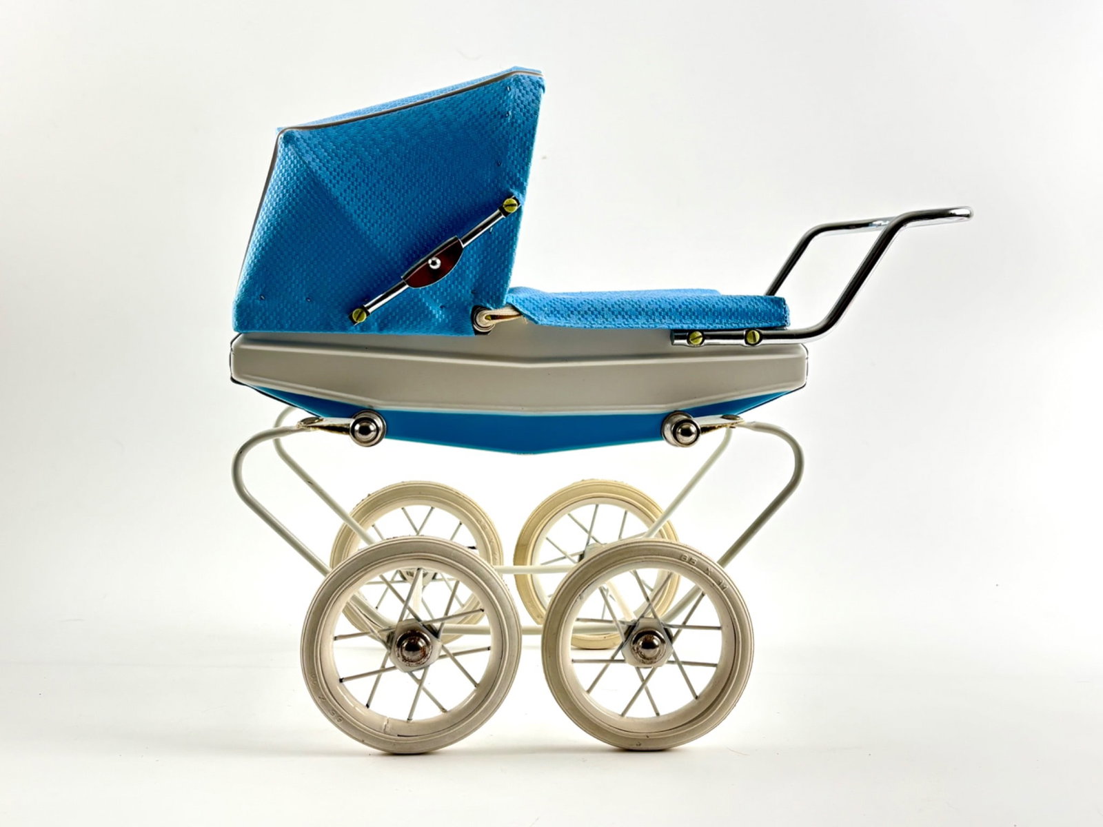 Doucet Baby Carriage with Original Box, Made in France: A Doucet brand baby carriage toy featuring a metal frame with four white spoked wheels. The carriage body has a white and blue finish with a textured blue vinyl canopy. The handle is chrome-toned meta