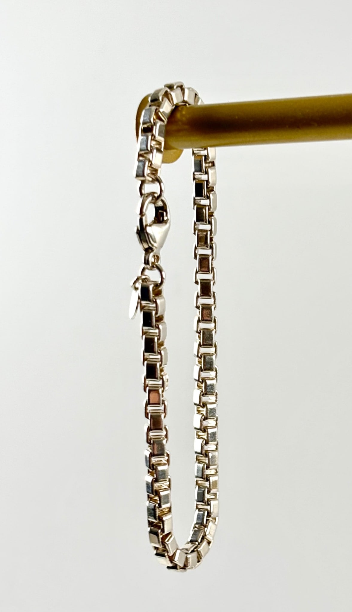 Tiffany Sterling Silver Venetian Link Bracelet with Original Pouch: Tiffany sterling silver Venetian link bracelet featuring a round charm engraved with 925 and the Tiffany and Co. hallmark. Secures with a lobster clasp. Includes the original turquoise felt pouch with