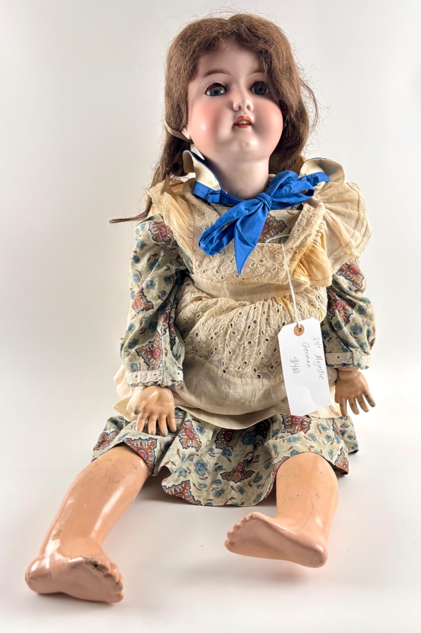 34 Inch Magestic German Bisque Head Doll with Composition Body: German bisque head doll measuring approximately 34 inches tall with a composition body. Features sleeping eyes, painted facial details, and an open mouth revealing teeth. Wearing a vintage style flora