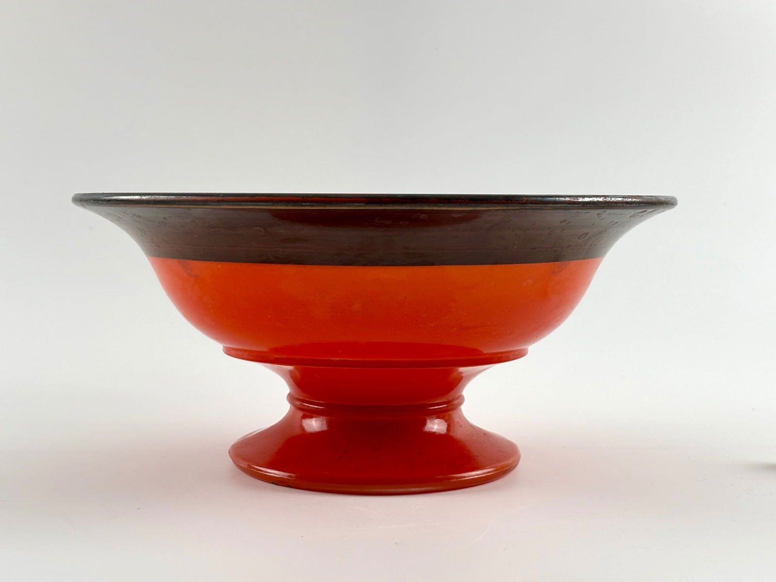 Vintage Art Deco Reversse Painted Compote: Glass pedestal bowl featuring a vibrant orange body and black rim. The black rim is adorned with an etched decorative pattern of floral motifs and bird designs. The bowl is elevated on a footed base.
