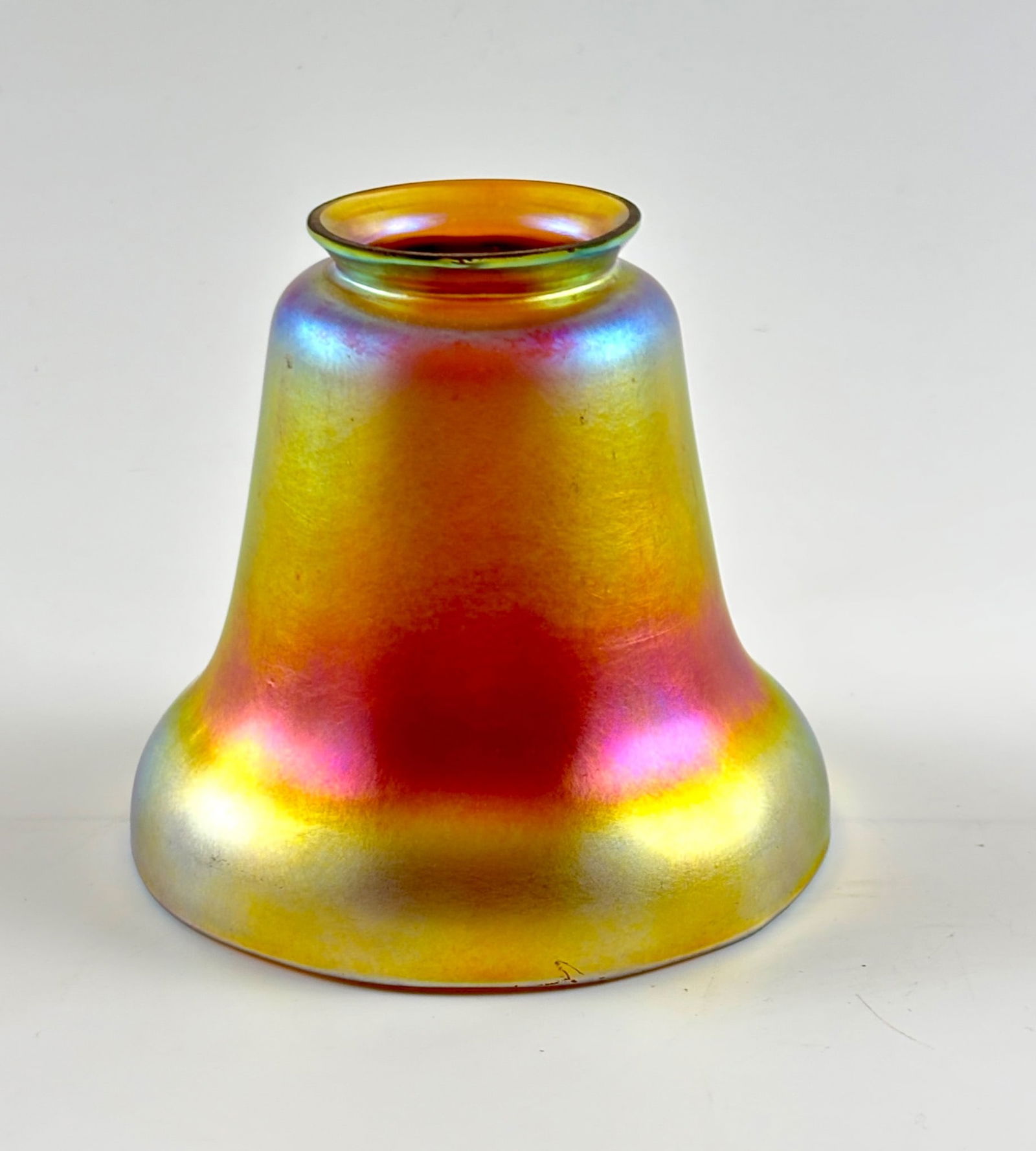 Steuben Iridescent Glass Lampshade with Hallmark: Steuben iridescent glass lampshade featuring vibrant hues of gold, pink, and blue. Hallmark is present on the rim, as shown in the photos. The lampshade is in good condition with no chips, cracks, or