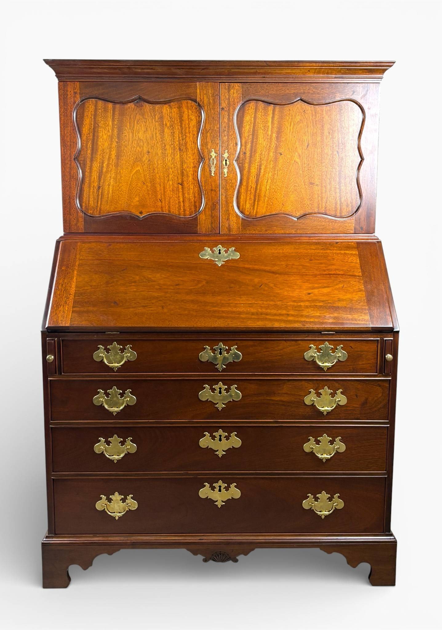 Kittinger Williamsburg Mahogany Slant Top Secretary Desk: Two piece Kittinger Williamsburg slant top secretary desk crafted from mahogany. Features a bookcase top with double paneled doors, detailed moldings, and interior compartments. The lower section has