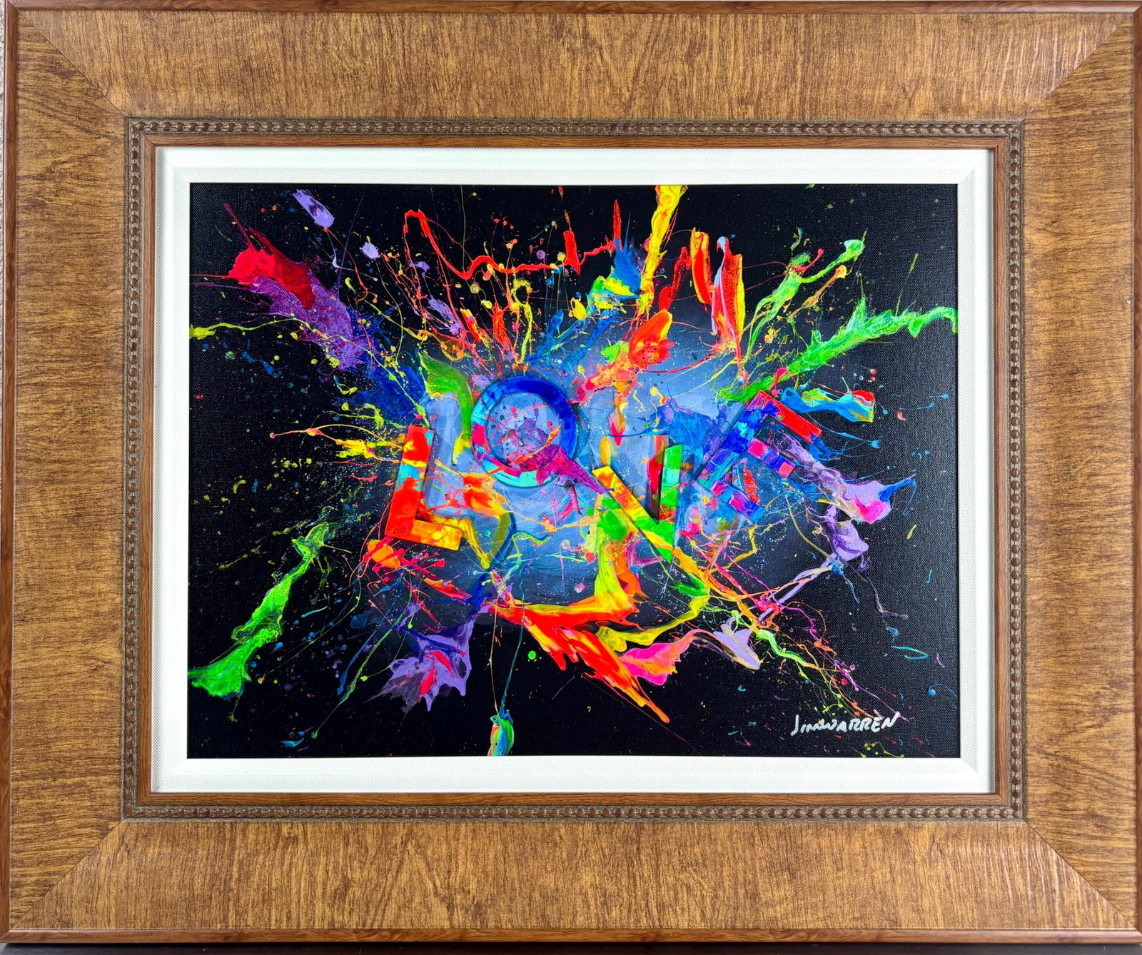 Jim Warren. Love in 3D. Hand Embellished Giclee on Canvas: Hand signed Love in 3D giclee on canvas by Jim Warren, produced in 2022 with vibrant, splatter style neon elements forming the word LOVE against a black background. Framed with a patterned brown wood