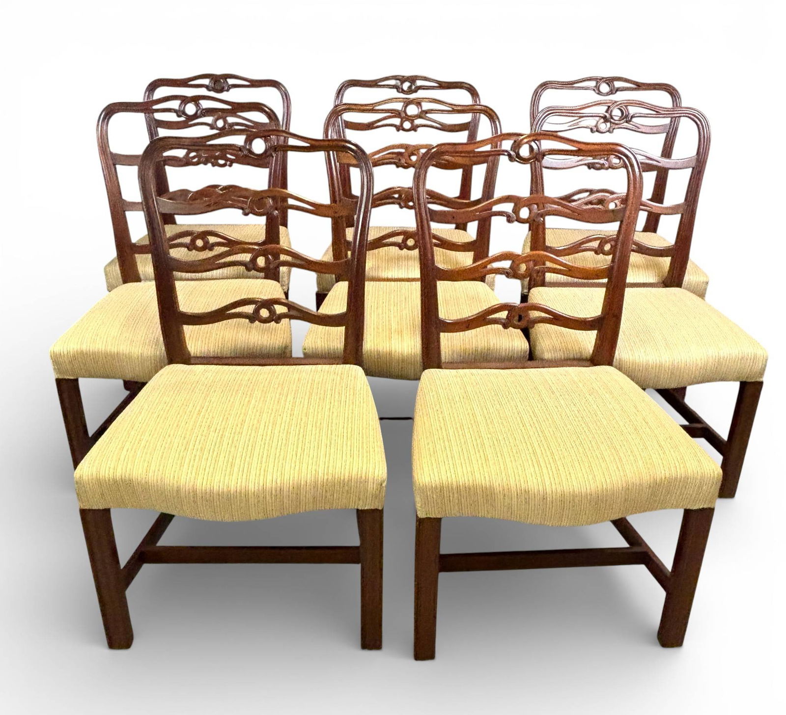 Eight Kittinger CW Ladder Back Chairs CW-17: Eight mahogany dining chairs marked with Colonial Williamsburg Foundation branding underneath. Features serpentine ladder back design with central circular cutouts, upholstered seats with ribbed