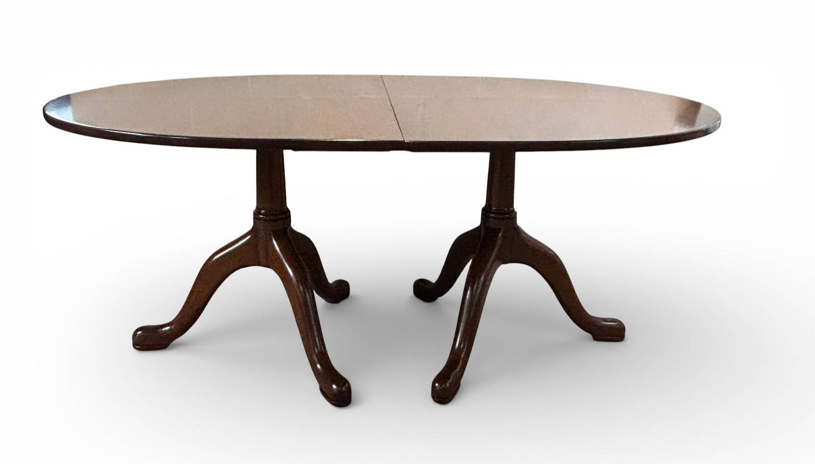 Kittinger Mahogany Pedestal Dining Table with Two Leaves: Kittinger mahogany dining table featuring a double pedestal base with cabriole legs terminating in pad feet. Includes two leaves for extended seating capacity. The mahogany showcases a polished