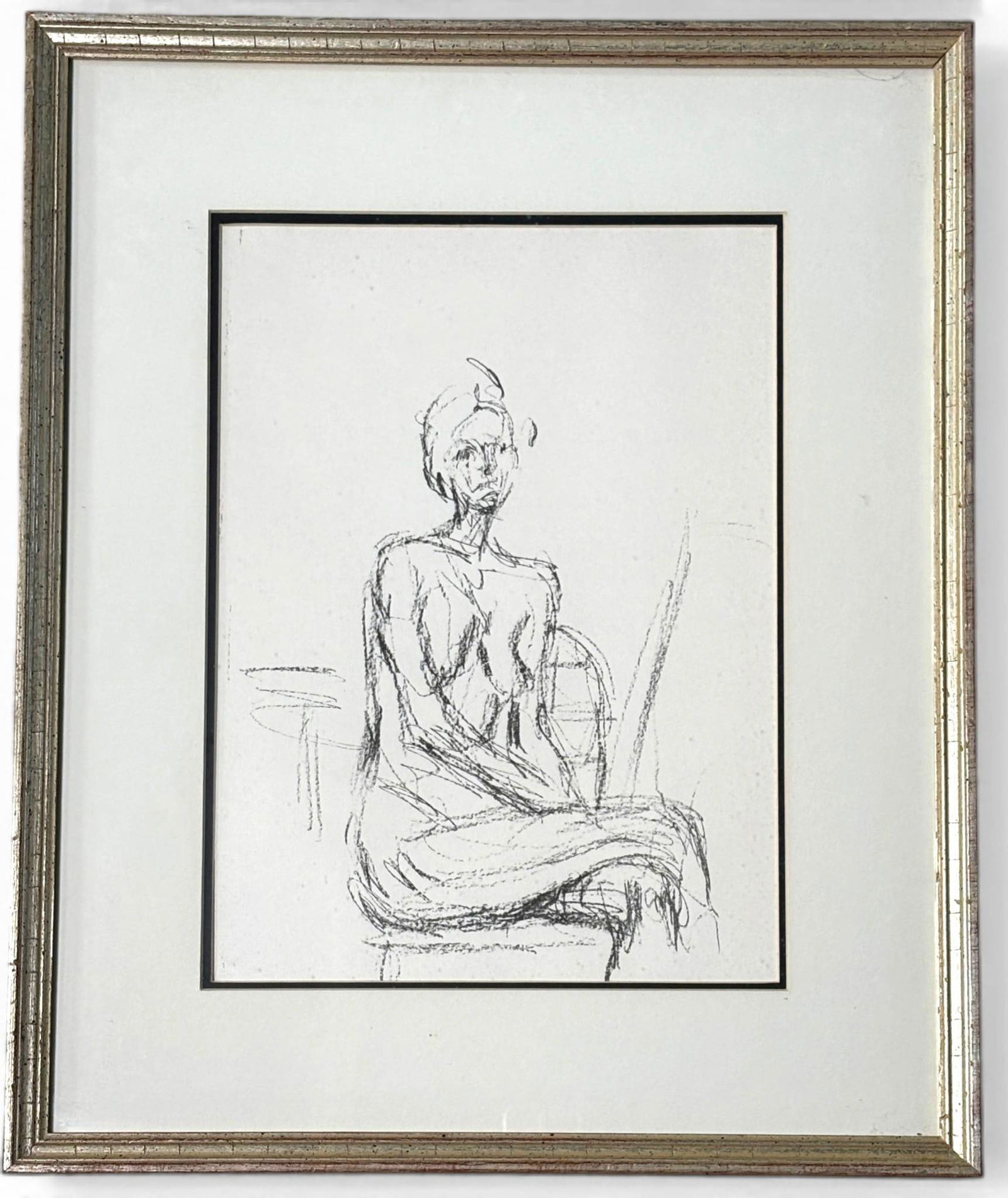 Alberto Giacometti Lithograph Seated Nude with COA: Lithograph titled Seated Nude by Alberto Giacometti, depicting a seated figure rendered in the artists characteristic sketch like lines. The artwork is framed in a silver finish frame with a cream col