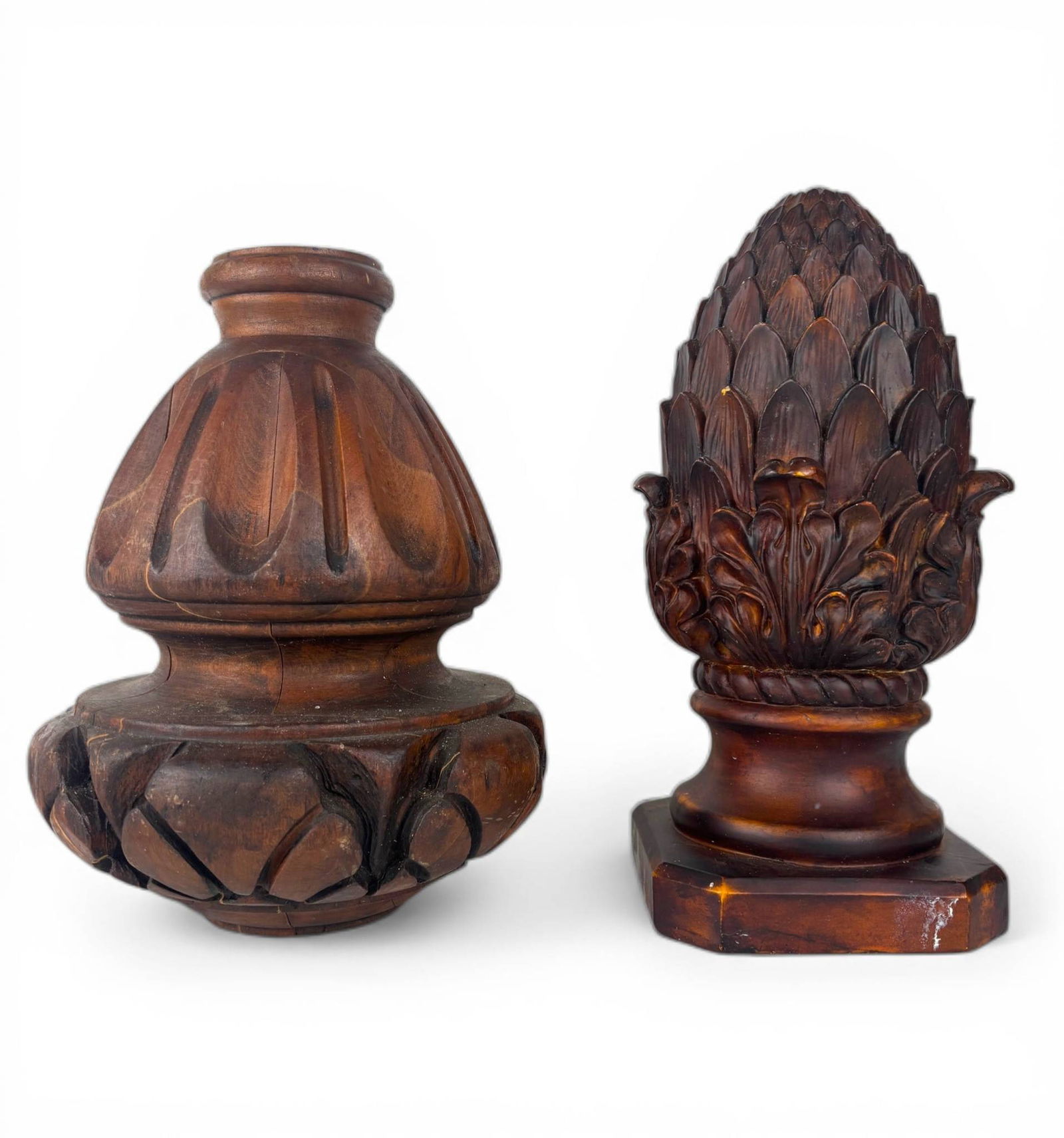 Carved Wood and Composite Decorative Finials: Carved wood and composite decorative finials, including one with a stylized pinecone design on a square base and another with an acorn motif with detailed carvings. Both pieces show signs of wear,
