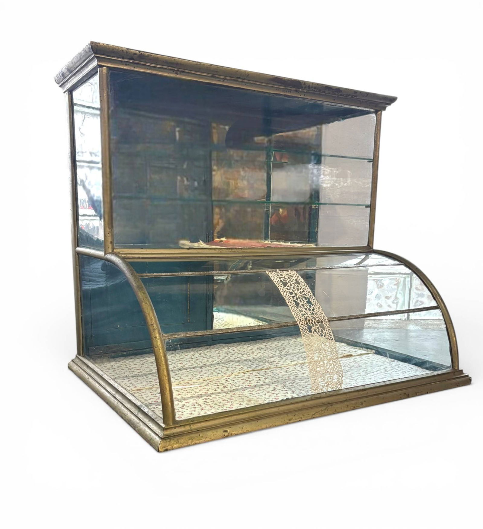 Antique Curved Humpback Mercantile Display Case with Glass Shelves: Antique curved humpback mercantile display case featuring a brass colored metal frame and glass construction, including curved glass panels at the front. Includes multiple glass shelves and a wooden