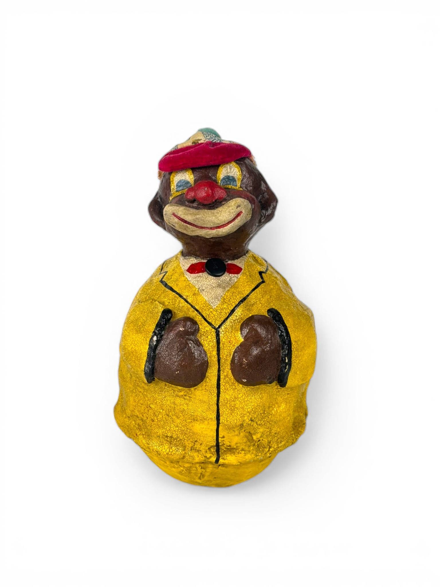 Paper Mache Rolly Polly Clown Figurine with Yellow Jacket: Paper mache rolly polly clown figurine featuring a hand painted design. The clown is depicted wearing a yellow jacket with black trim, red bow tie, and a multicolored cloth hat with a red felt brim. T