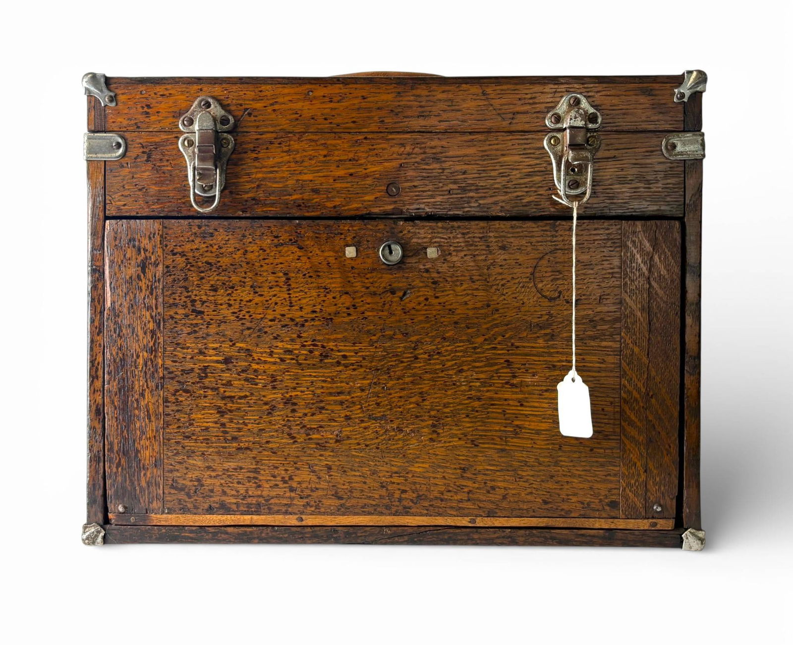 Wooden Storage Box with Metal Hardware and Keyhole: Rectangular wooden storage box made from oak with visible grain patterns and a hinged lid. Box remains locked. Features antique metal corner reinforcements, latches for securing the lid, and a central