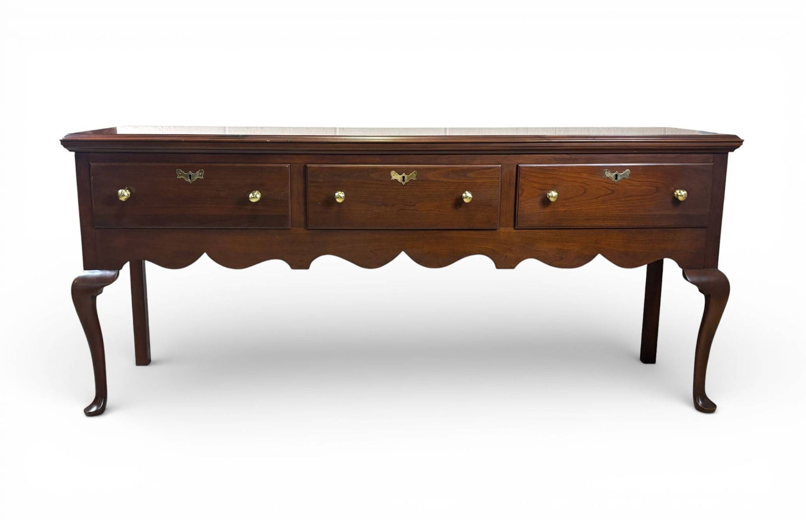 Henkel Harris Cherry Wood Huntboard with Three Drawers: Henkel Harris huntboard made of rich cherry wood. Features a rectangular top with a beveled edge, three drawers with dovetail joinery, brass hardware, and a scalloped apron. Stands on cabriole front