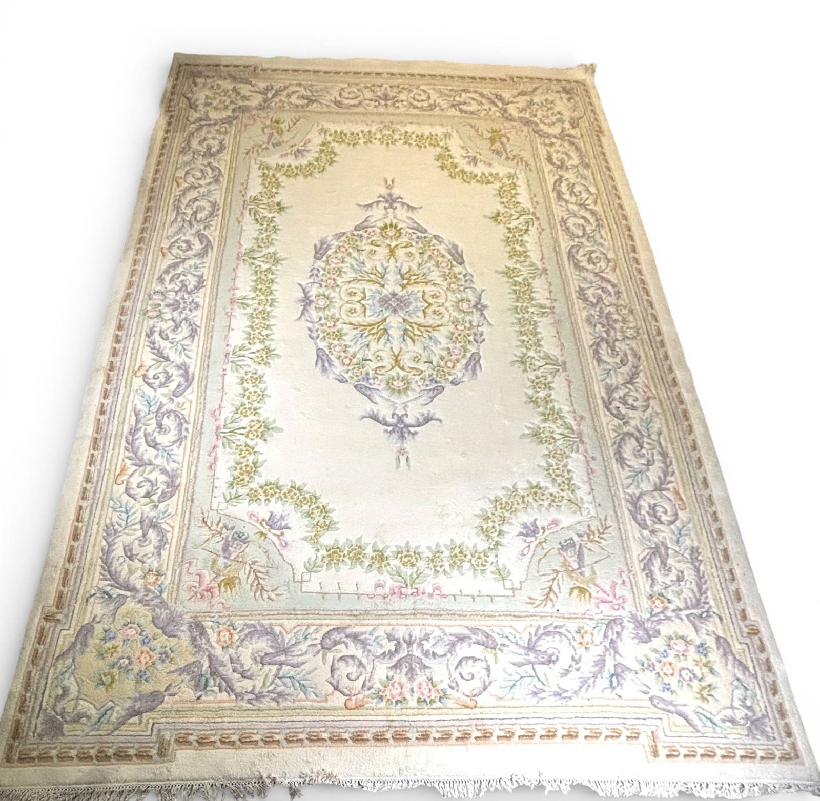 French Aubusson Rug with Floral and Scrollwork Motifs 12 x 18: Handwoven French Aubusson rug featuring an intricate central medallion surrounded by floral garlands and scrollwork. The pale cream background is accented with soft pastel tones, including lavender,
