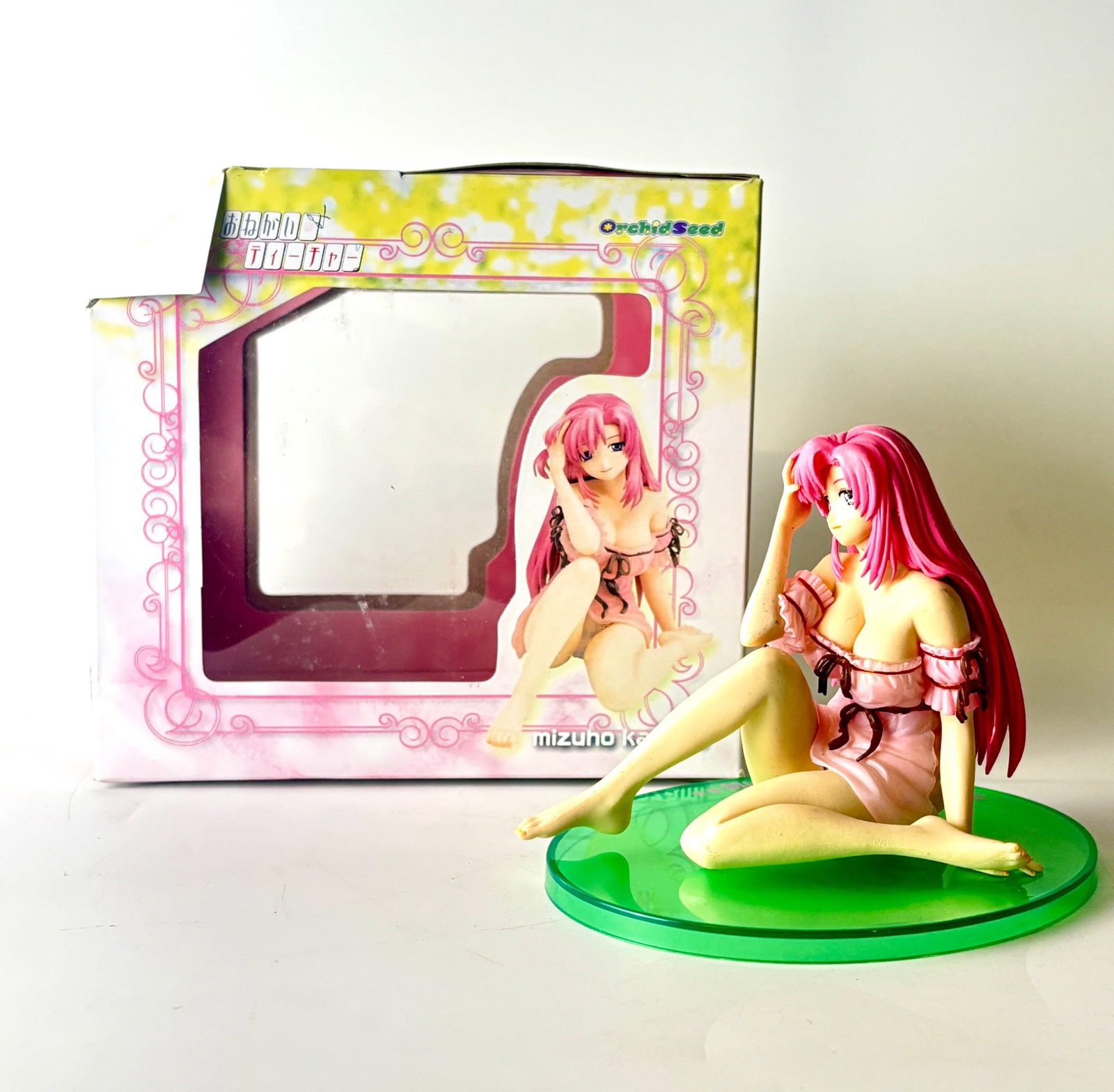 Onegai Teacher Mizuno Kazami Wave Corporation: 1/7 scale PVC figure of Mizuno Kazami from the anime series Onegai Teacher, produced by Wave Corporation. Features a seated pose with detailed sculpting, a pink outfit, and a green circular display ba