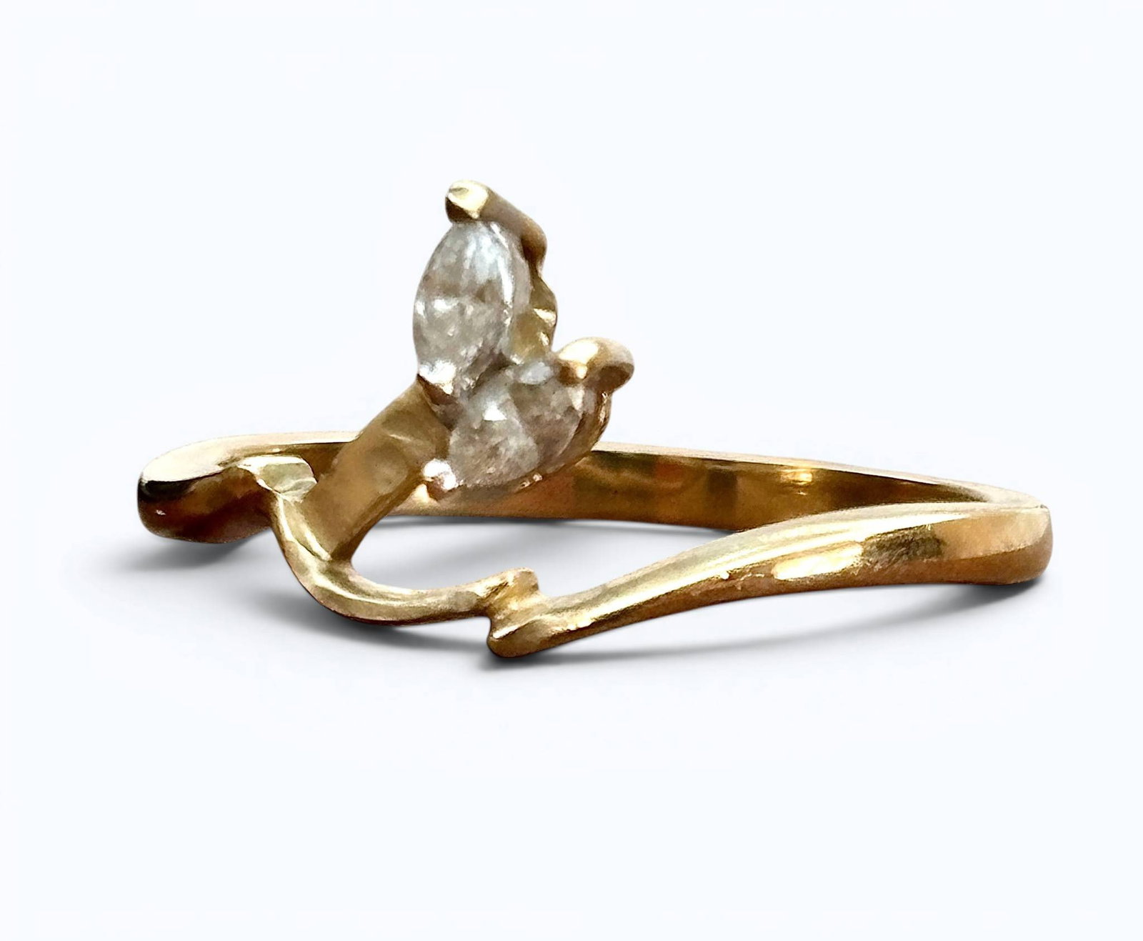 14K Yellow Gold and Diamond Ring: 14K yellow gold ring with a bypass-style band, showcasing two marquise-cut diamonds set in a prong setting. The interior of the band is stamped with gold purity markings. The ring exhibits minor wear 