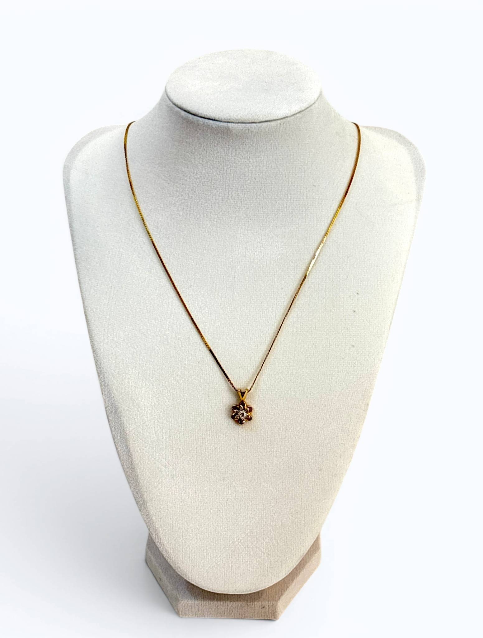 14K Gold Petit Diamond Flower Pendant Necklace: 14K yellow gold chain necklace featuring a flower-shaped pendant with an inset diamond accent at the center. The pendant is designed with a polished openwork style. The chain is a fine twisted rope pa