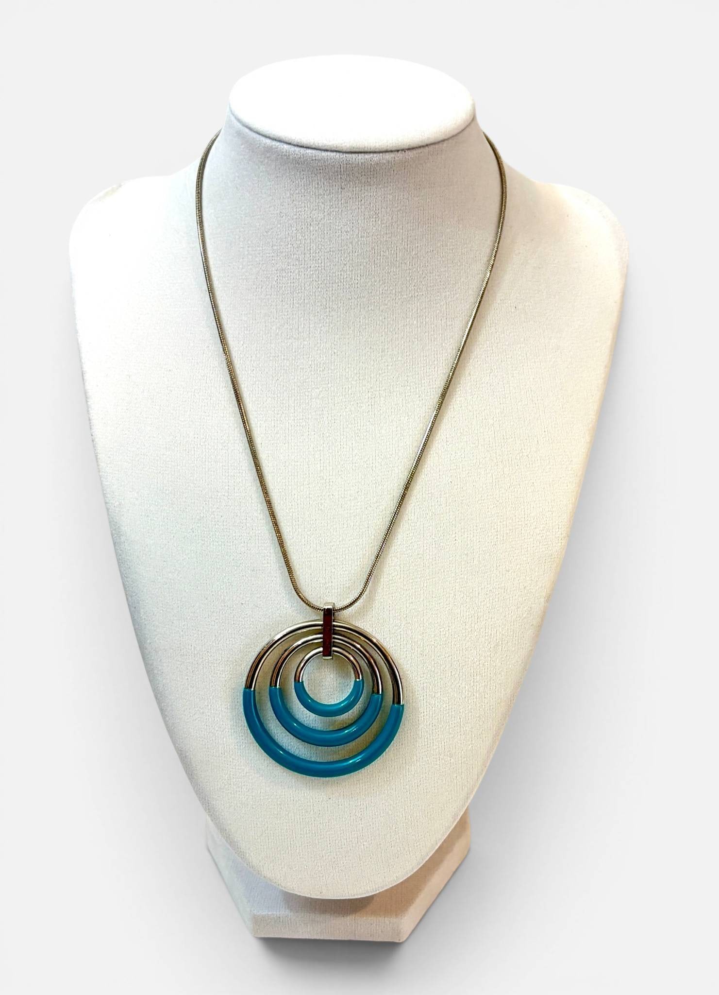 Blue Enamel Circle Pendant Necklace: Silver tone necklace featuring a multi circle pendant design with blue enamel accents on each circular segment. The piece includes a snake style chain with a lobster claw clasp and an extender chain f