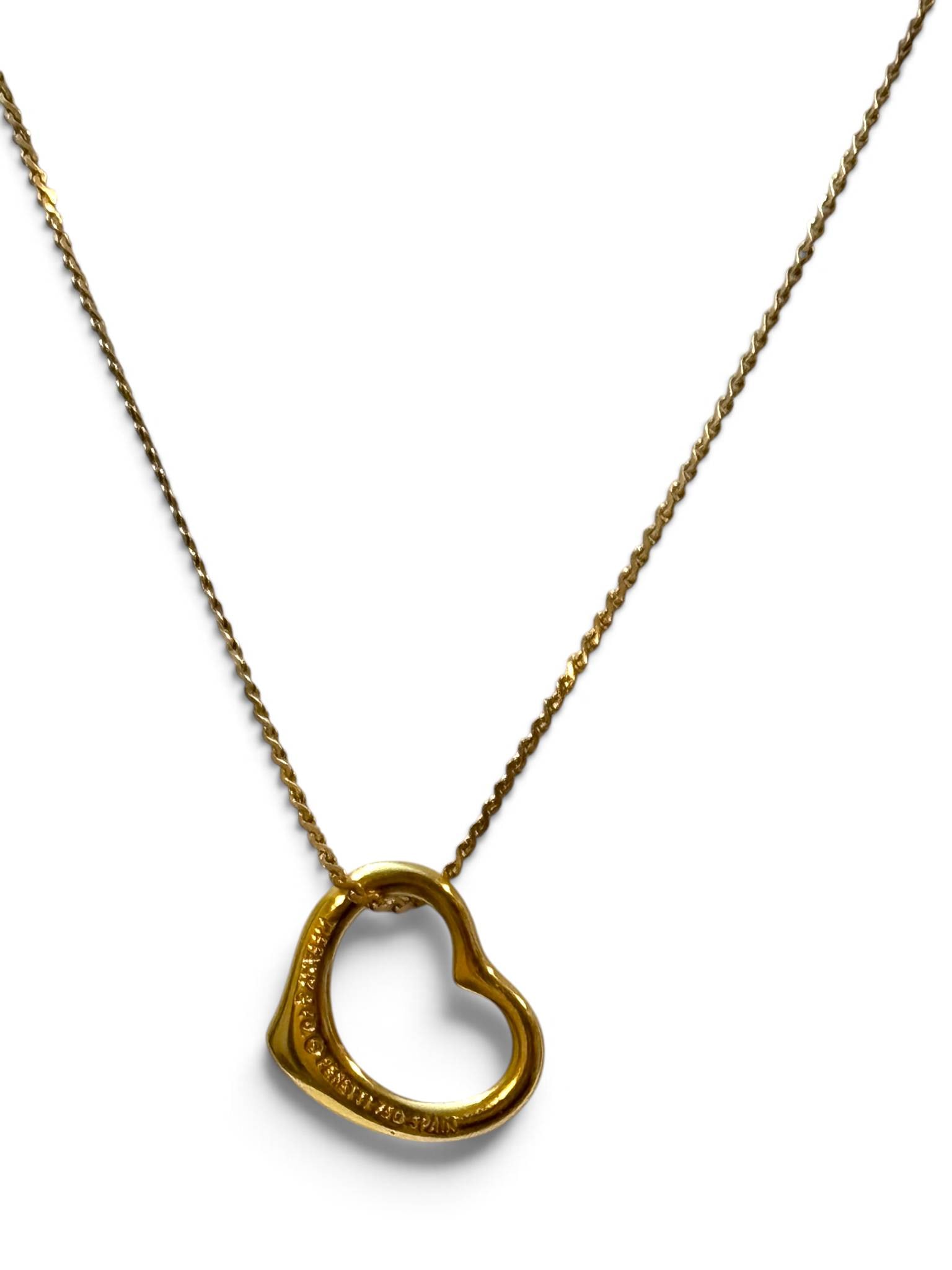 Tiffany & Co. Elsa Peretti 18K Yellow Gold Open Heart Necklace: Tiffany & Co. Elsa Peretti open heart pendant necklace crafted in 18K yellow gold. The iconic open heart pendant bears engraved branding and material mark: ‘Tiffany & Co., Peretti, 750, Spain.’ Su