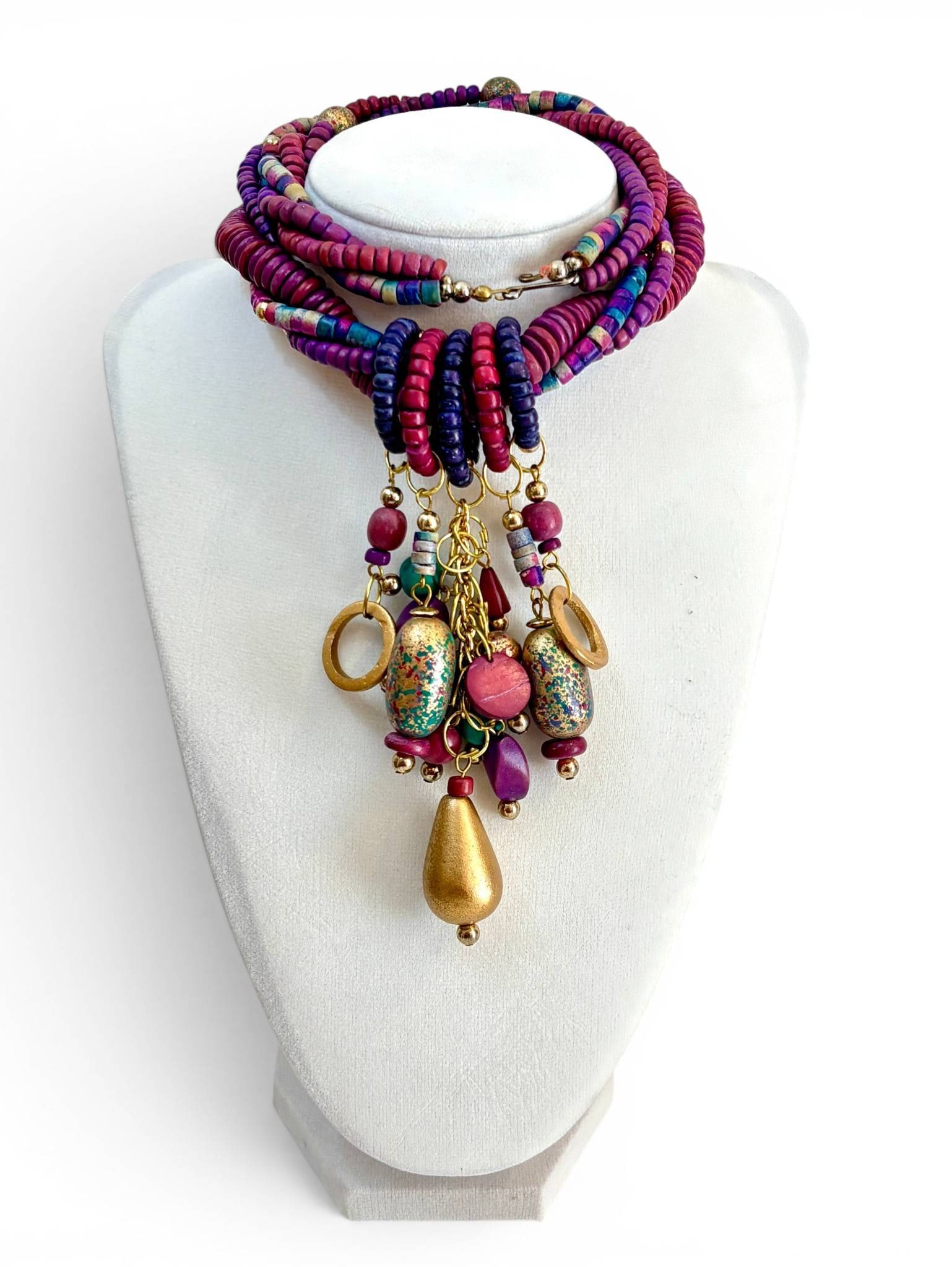 Vinatge Multistrand Necklace With Colorful Beads: Multistrand necklace featuring vibrant hues of purple, pink, and blue beads with marbled patterns. Includes dangling embellishments with gold-tone elements, round and teardrop beads, and hook clasp