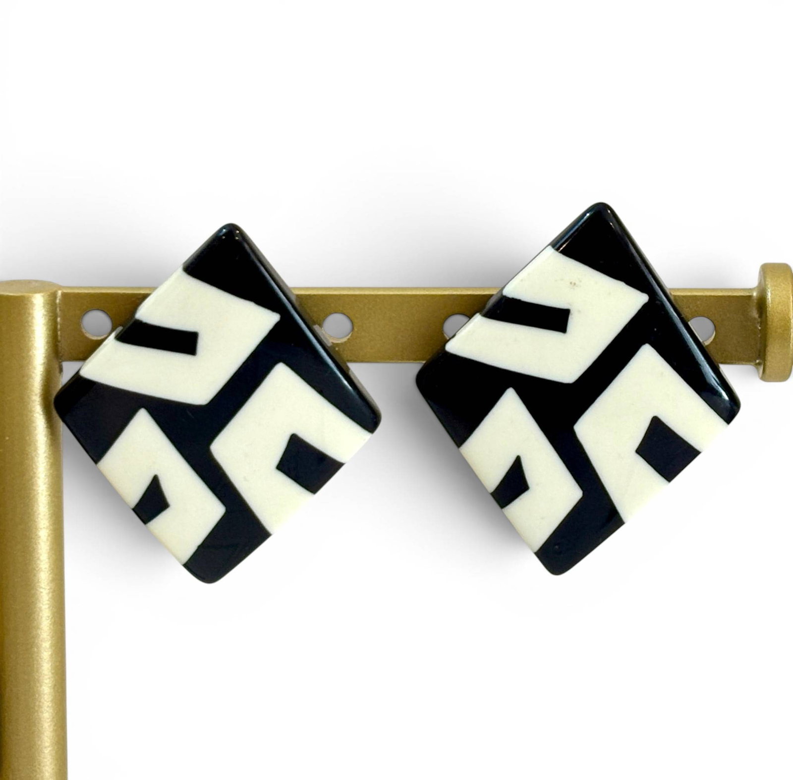 Black and White Geometric Resin Stud Earrings: Square-shaped geometric earrings featuring a black and white resin design with an abstract pattern. Earrings have a post-back fastening and measure approximately 1 inch by 1 inch. The design includes