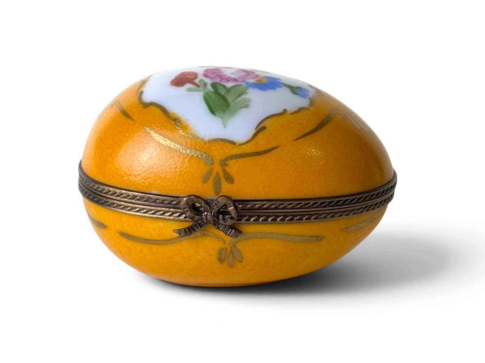 Hand-Painted French Limoges Yellow Floral Egg: Oval-shaped hand-painted porcelain trinket box from Limoges, France, featuring a yellow exterior with floral motifs and gilt decoration. The hinged lid is accented with brass trim and a bow clasp. Int