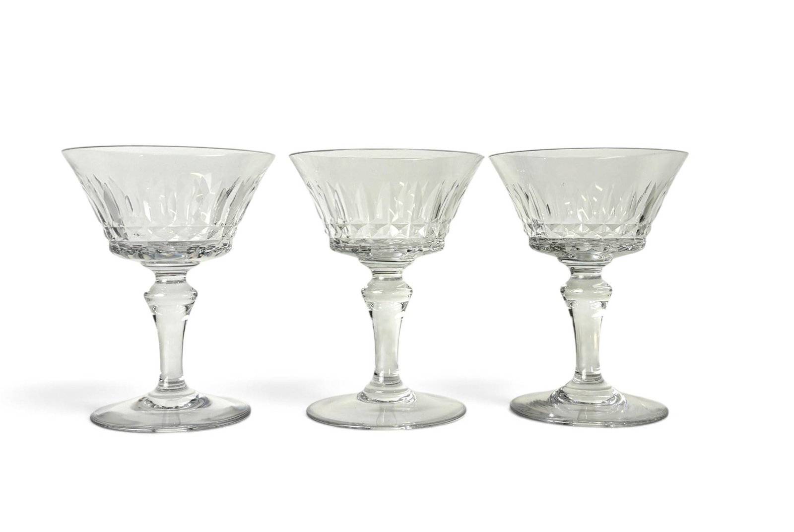 Three Baccarat Piccadilly Champagne Coupes: Three Baccarat ‘Piccadilly’ crystal champagne coupes featuring faceted bowls with radiating cut designs and stems with subtle geometric details. The saucer-shaped bowls showcase Baccarat’s