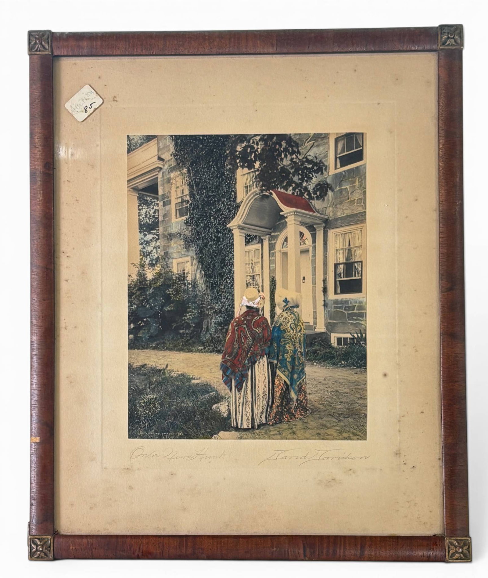 Framed Colored Print by David Davidson, Signed: Framed colored print by artist David Davidson, depicting two women in elaborate shawls standing near a building with ivy-covered walls and a detailed porch. Signed by the artist on the lower right