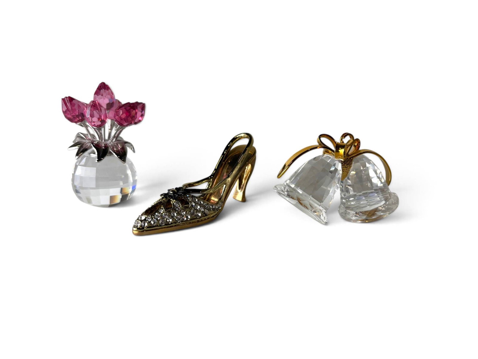 Swarovski Crystal Miniatures Set: Three Swarovski crystal miniatures featuring a tulip vase with faceted pink crystal tulips and polished metal leaves, a gold-tone high-heeled shoe embellished with clear crystals and floral accents,