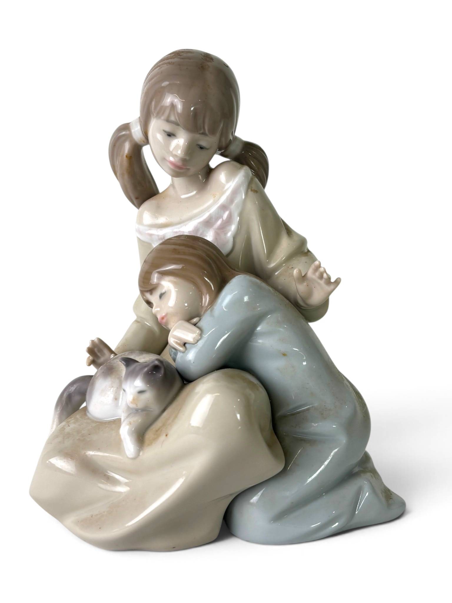 Lladro Porcelain Figurine Model #1534: A glossy porcelain figurine by Lladro titled ‘Childhood Companions’ (Model #1534), featuring two children in muted pastel clothing and a cat resting on a lap. Marked on the bottom with the blue