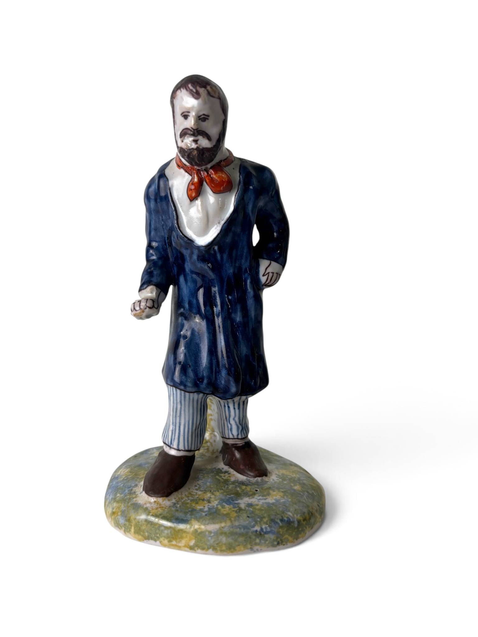 Pair Old Quimper French Faience Figurines: Hand-painted faience figurines from Old Quimper, France. Includes a bearded male farmer in a blue coat with striped trousers and a red scarf, and a woman wearing a blue shawl, green apron, and