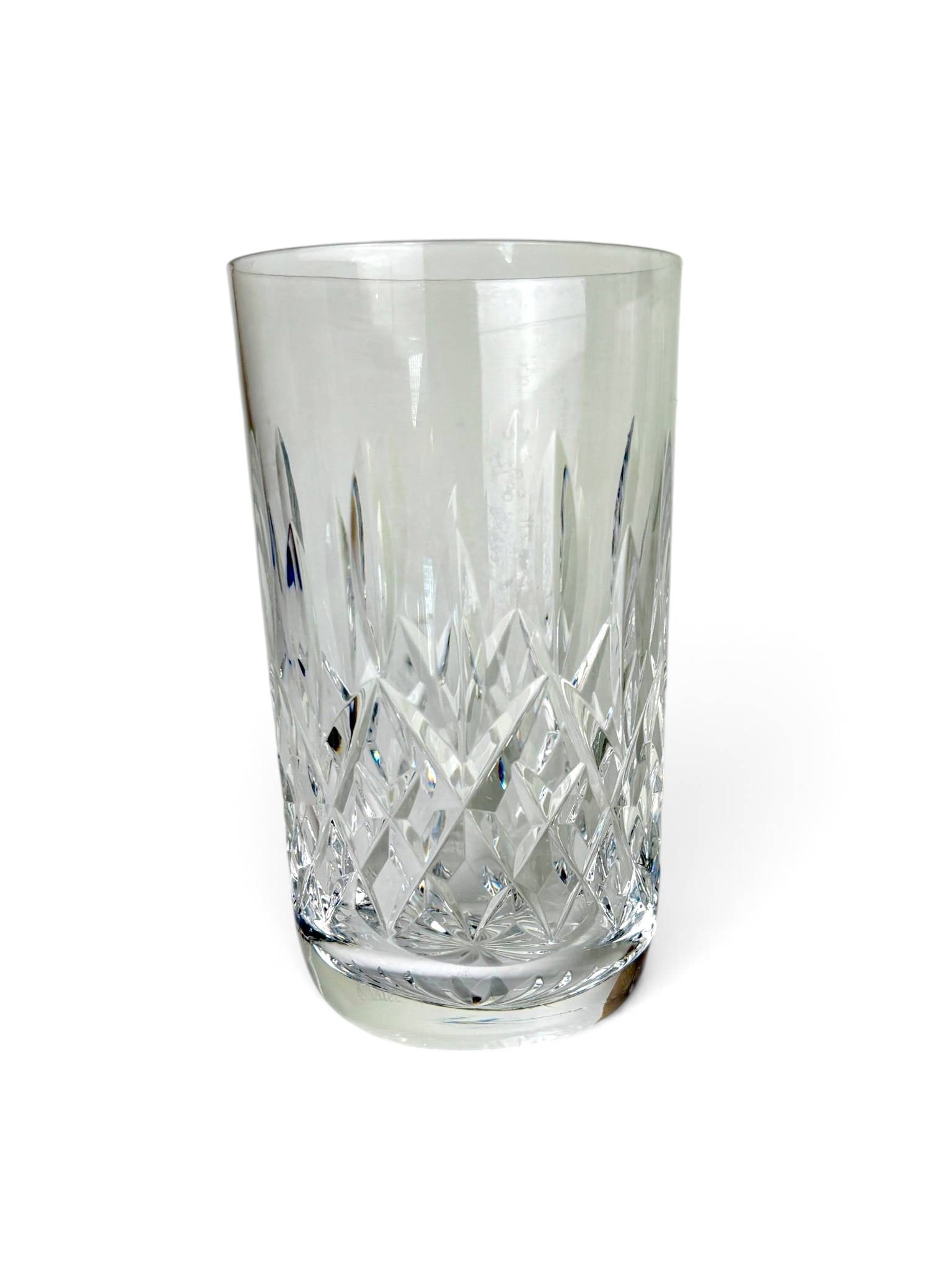 8 Waterford Lismore Highball Glasses: 8 Waterford Lismore highball glasses crafted from clear lead crystal. Features the iconic diamond and wedge-cut pattern synonymous with the Lismore design. Each glass has a flat base with radiating