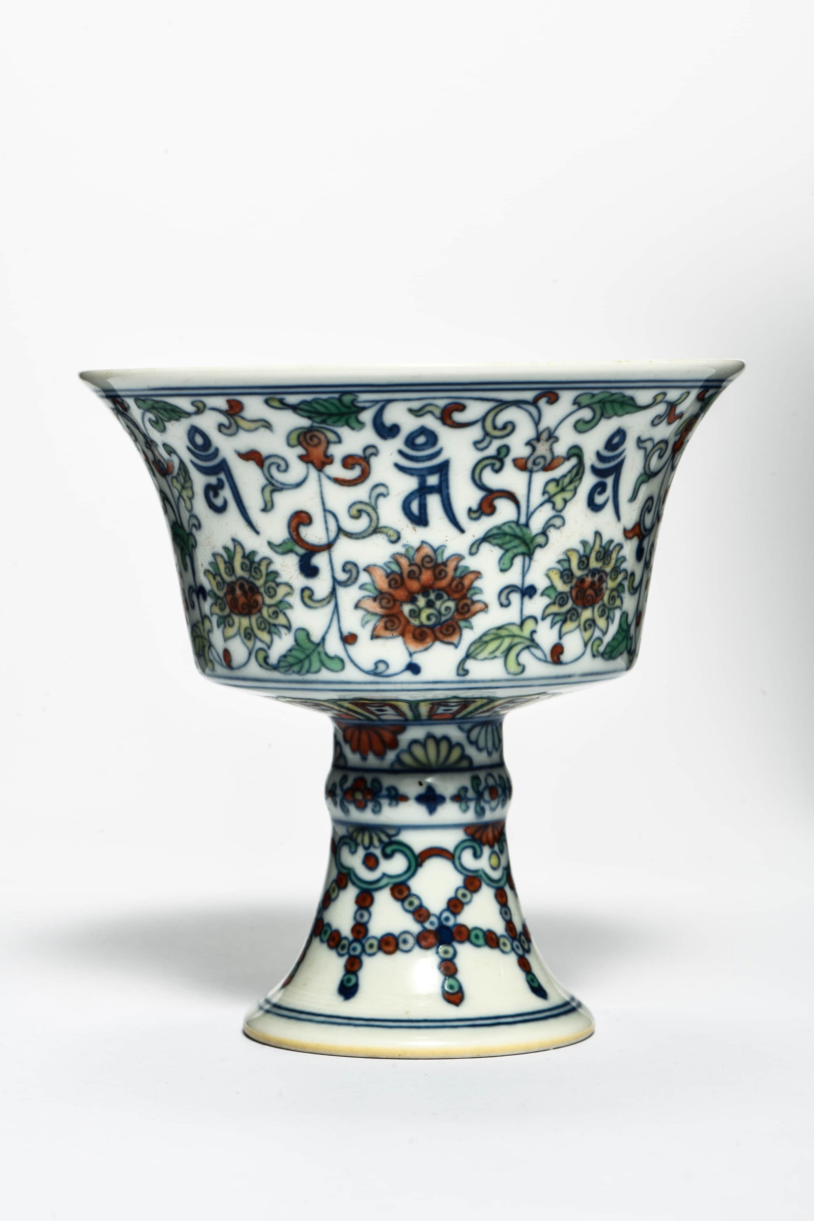 A DOUCAI 'SANSKRIT SCRIPT AND EIGHT BUDDHIST EMBLEMS' STEM CUP: A DOUCAI 'SANSKRIT SCRIPT AND EIGHT BUDDHIST EMBLEMS' STEM CUPDescription:Diameter: 10.5 cm Height: 10.5 cm