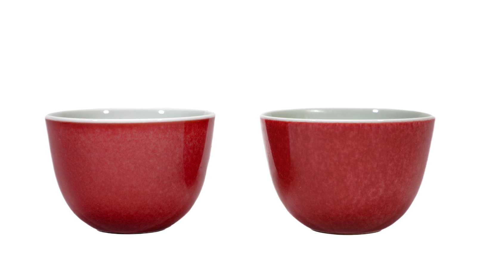 A PAIR OF RED-GLAZED CUPS: A PAIR OF RED-GLAZED CUPS Dimensions: Width: 6.5 cm (2.6 in.), Height: 4.5 cm (1.8 in.). All measurements are approximate.