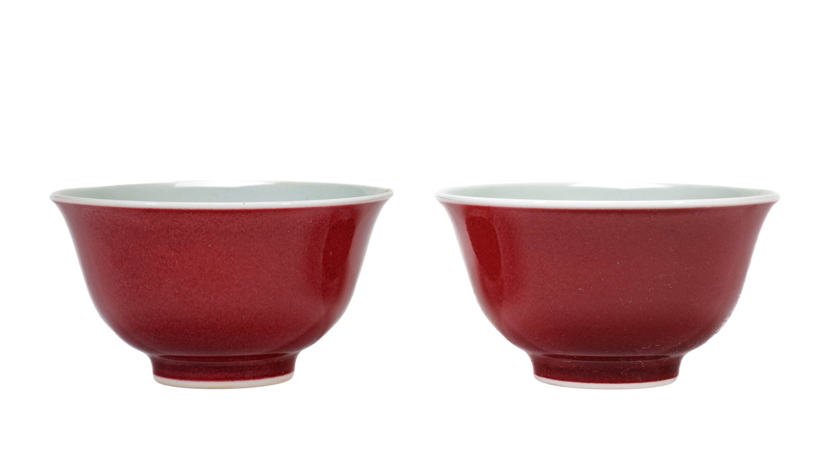 A PAIR OF RED GLAZED CUPS: A PAIR OF RED GLAZED CUPS Dimensions: Width: 8 cm (3.1 in.), Height: 4.5 cm (1.8 in.). All measurements are approximate.