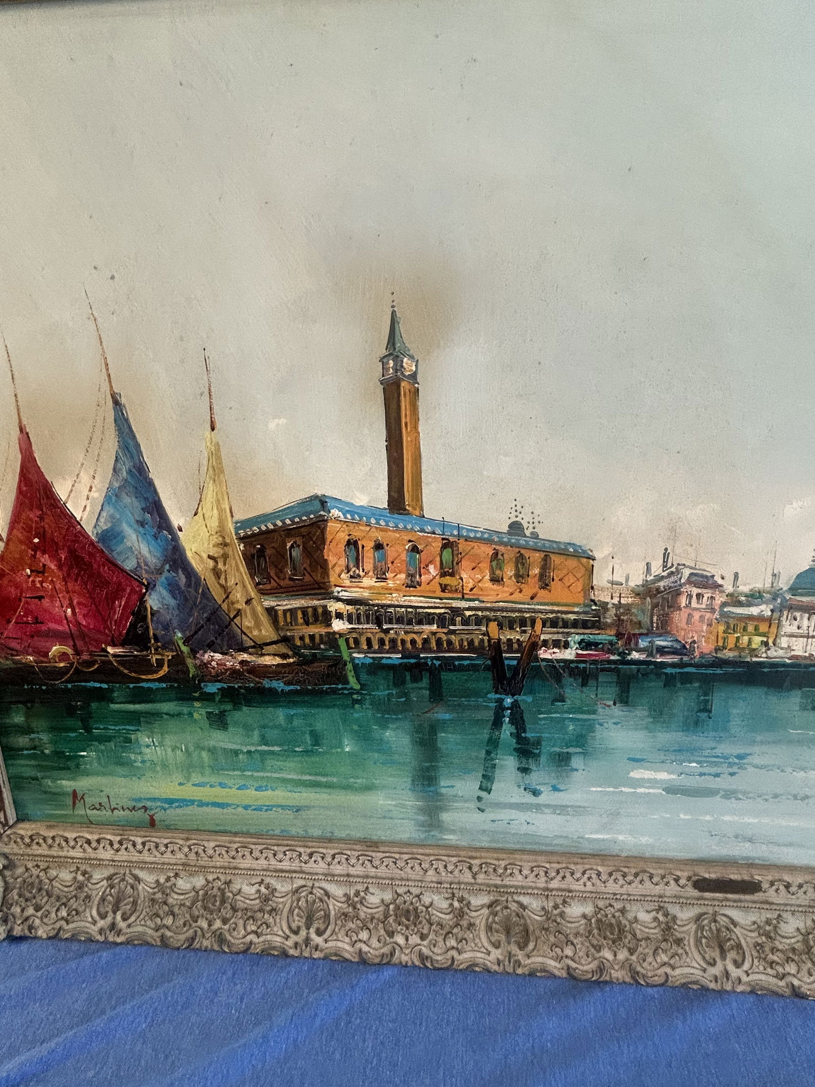 Vintage Venice Oil Painting by P. Martinez: Large vintage oil painting of Venice, featuring three colorful sails of sailboats and the Doge’s Palace. Framed in ornate gold frame. Note small damage due to age on the frame.