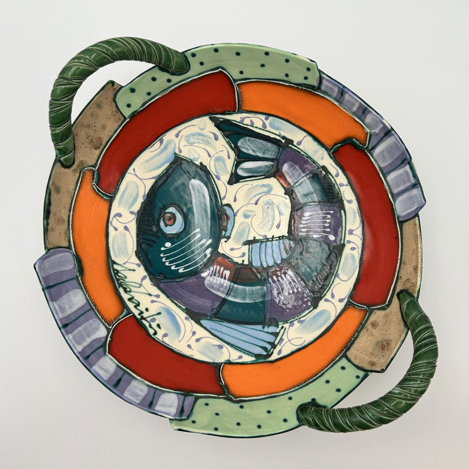 Hand-Painted Fish Platter with Handles by Juozas and Rasa Saldaitis: This hand-painted ceramic fish platter with handles was created by artists Juozas and Rasa Saldaitis. It is a piece of modern, colorful decorative and applied art made in their studio in Pinellas