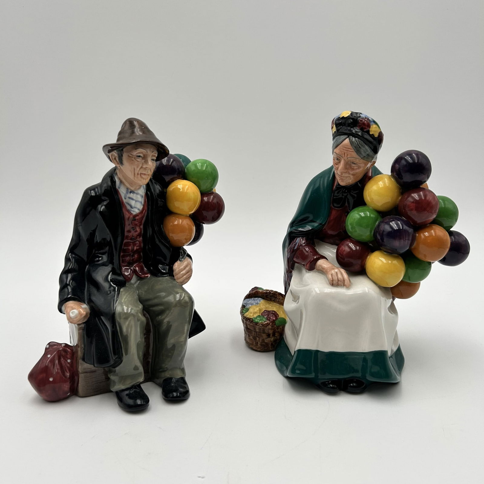 Royal Doulton England Figurine "The Old Balloon Seller" (H.N. 1315): This lot is for the OLD BALLOON SELLER only. The Royal Doulton "The Old Balloon Seller" (HN 1315) is a highly popular and well-known bone china figurine, introduced in 1929 and produced for nearly