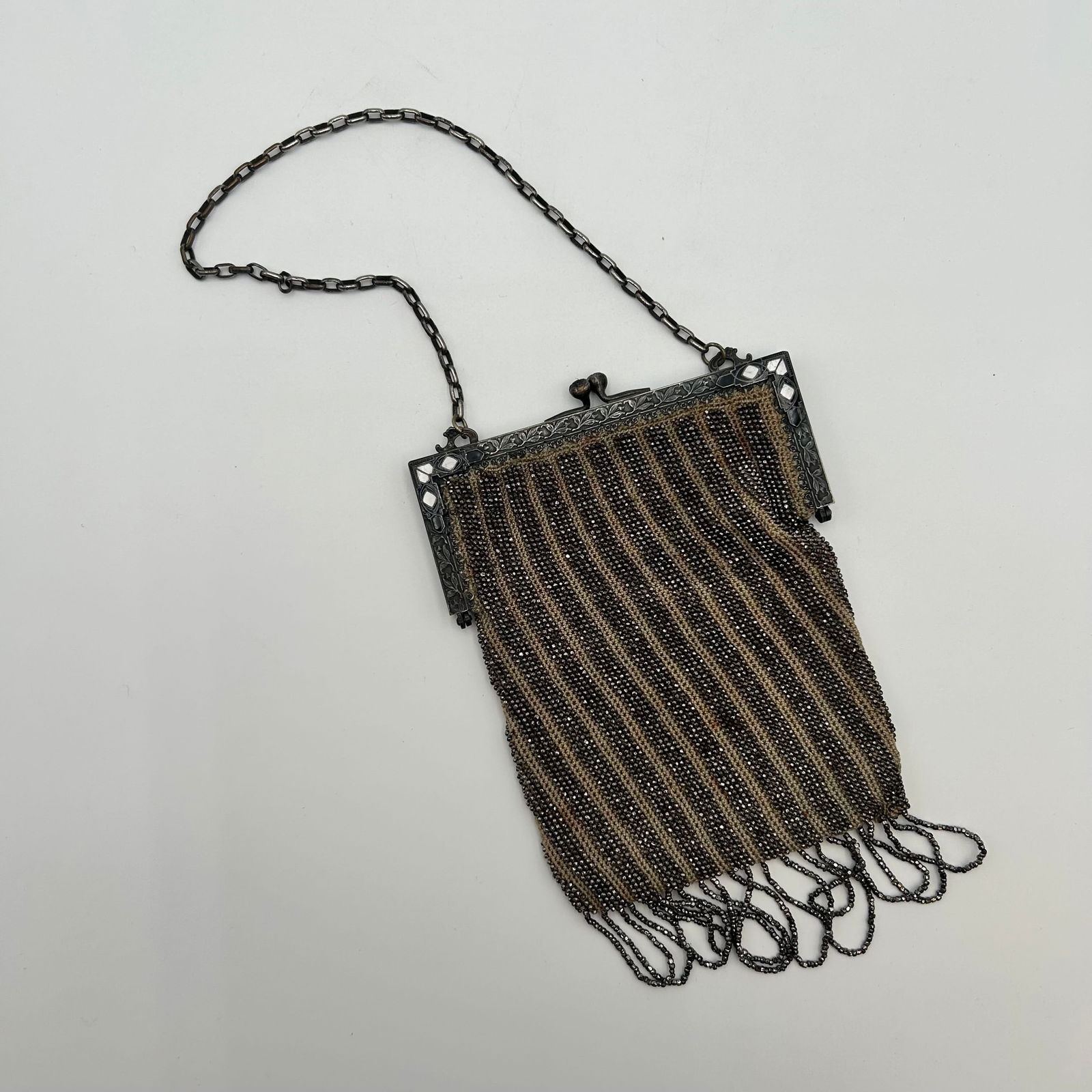 Antique 1920s Beaded Purse with Bead Fringe: Antique steel cut beaded purse, made in the 1920s. Flappers would frequently carry these Art Deco evening bags. It has a metal frame with intricate, filigree designs and a flower motif. In good vintag