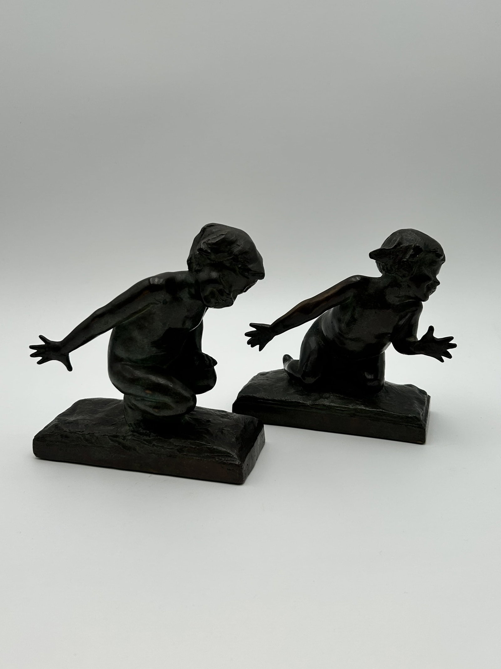 Patinated Bronze "Children Playing" Bookends by Edith Barretto Parsons (Pair): Pair of sculptures depict children in playful, natural poses. Created by American Sculptor Edith Barretto Parsons (1878-1956)> Cast by the Gorham Co. Foundry and are marked with copyright from 1913.