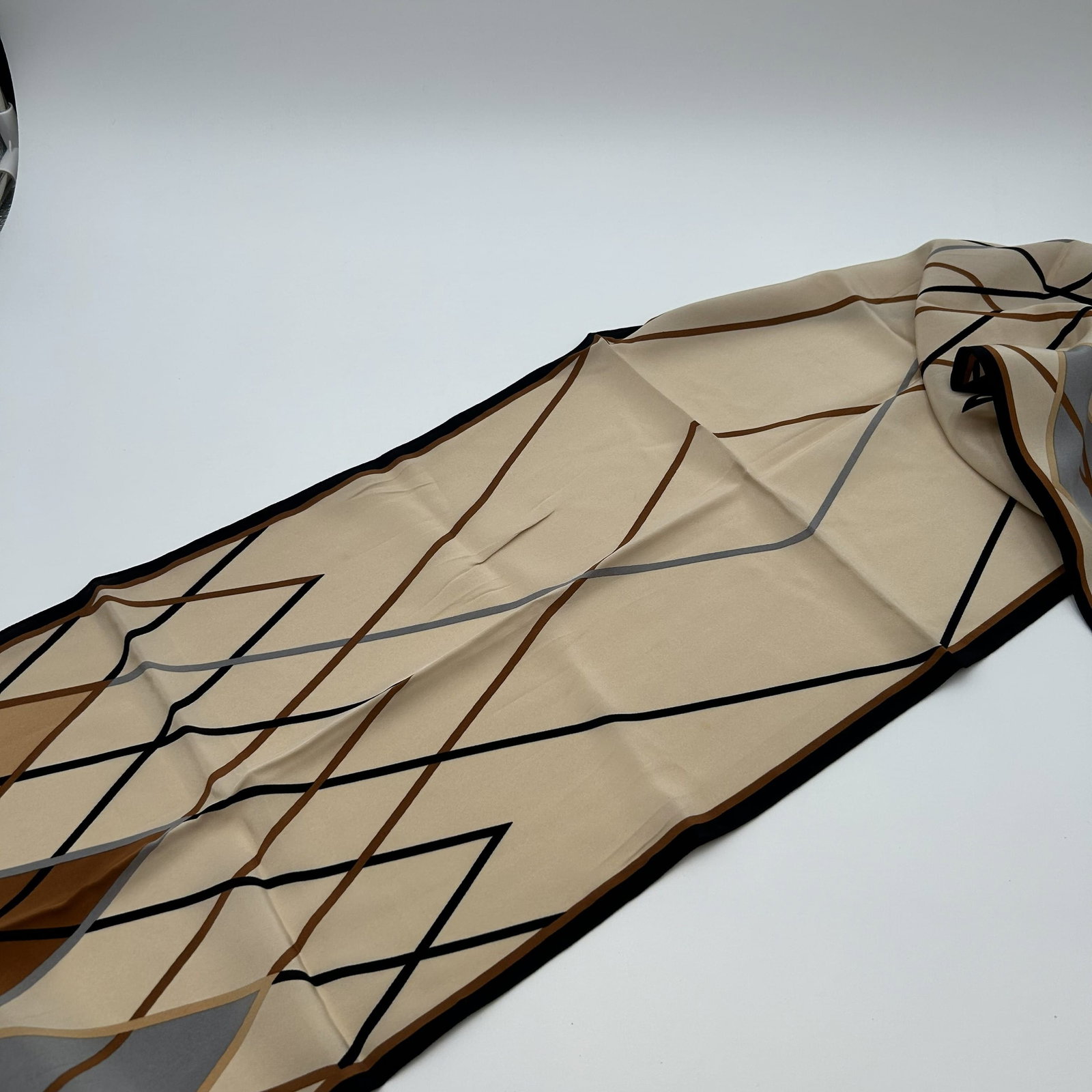 Vintage Black Beige Brown Steel JAEGER Scarf Made in Italy: The vintage black beige brown steel JAEGER scarf is a stylish accessory that exudes retro charm. Made in Italy from luxurious silk, this scarf features a sophisticated black, beige and brown color pal
