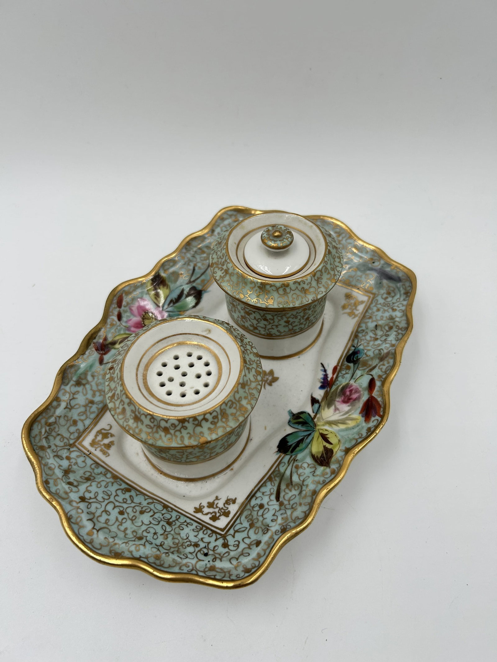 French-Style Porcelain Inkstand Set: This is a French-style porcelain inkstand set, featuring a tray, a covered inkwell, and a pounce pot. The two (2) wells attached to the base. Unmarked, but certainly well done with gold trim around ea