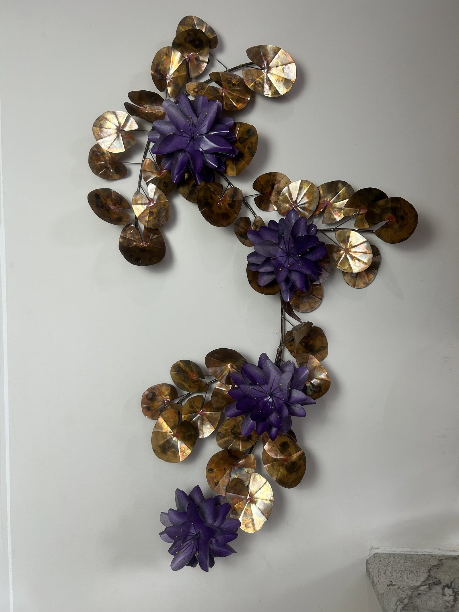 Brass Purple Flower Wall Sculpture: Vintage detailed purple flowers with leaves, connected by stems, wall sculpture. Artist unknown.