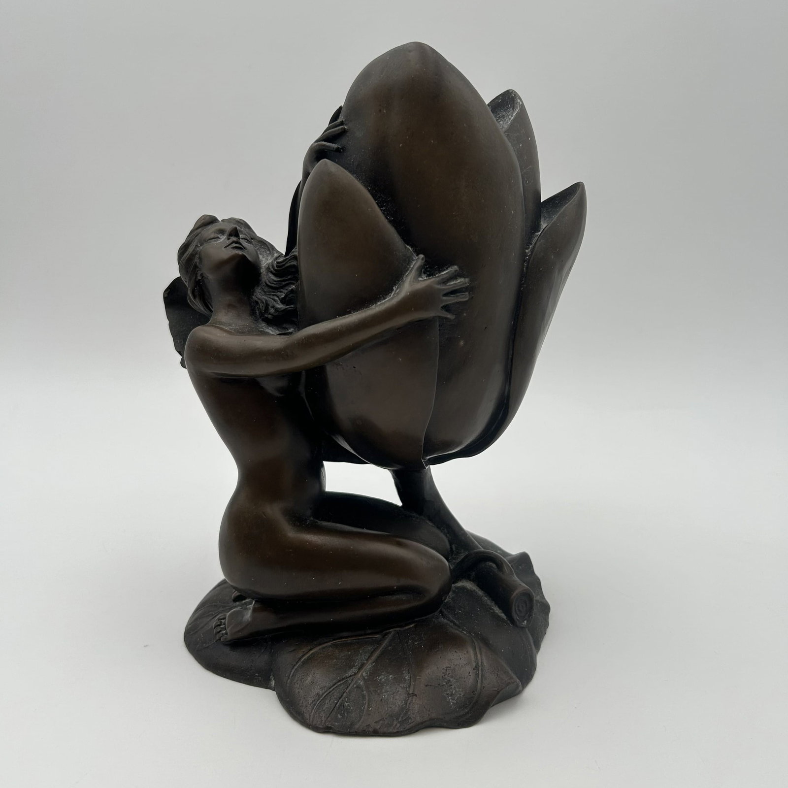 Art Nouveau-Style Bronze Figural Candleholder: This is a bronze candle holder of a woman holding a water lily, candleholder. Dimensions: 8" W x 6 1/2" D x 9 1/2" H