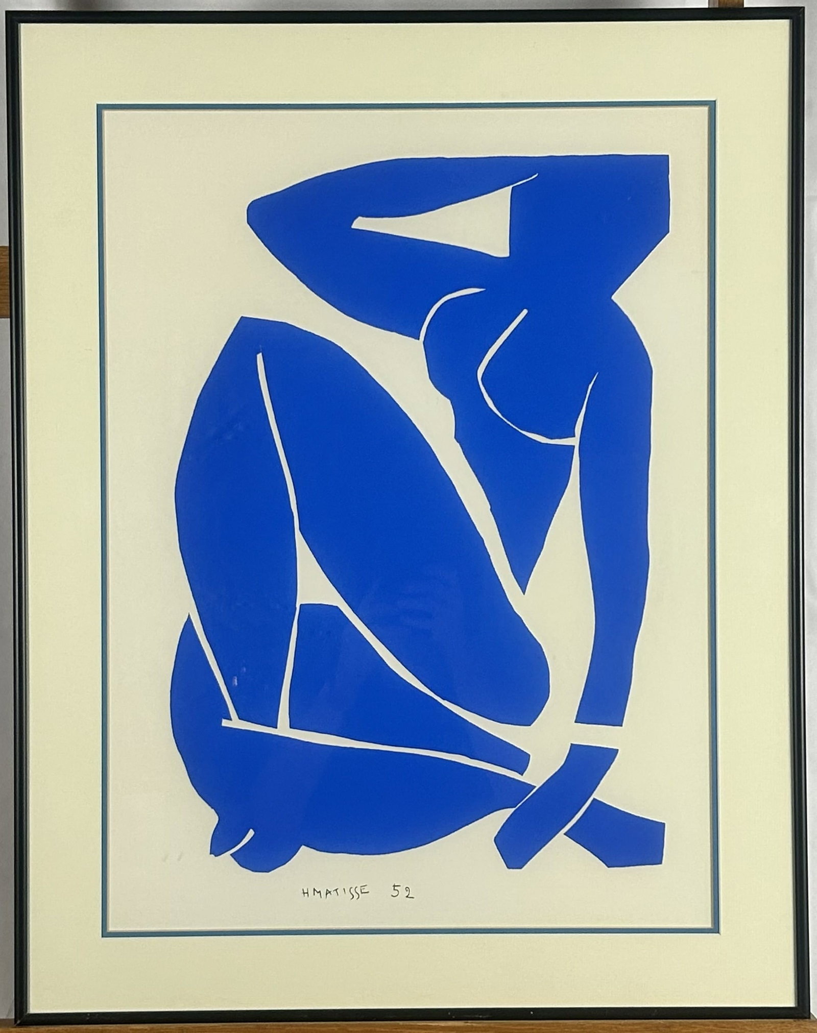 After Henri Matisse's Iconic 1952 Paper Cut-out "Blue Nude III" Framed Print Reproduction: This framed print is a reproduction after Henri Matisse's iconic 1952 paper cut-out "Blue Nude III", featuring a bold cobalt blue silhouette presented in a clean black frame. Dimensions - 22 1/4" W x 