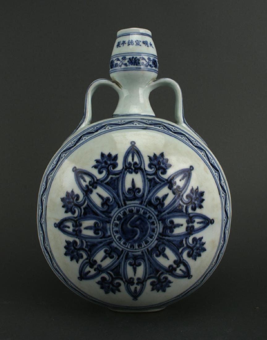 BLUE AND WHITE MOON FLASK: Blue And White Moon Flask: Blue and white moon flask with a six character mark at the top of the gourd-shaped neck. Applied, flat ribbon handles end at the shoulders, with a circular floral design in