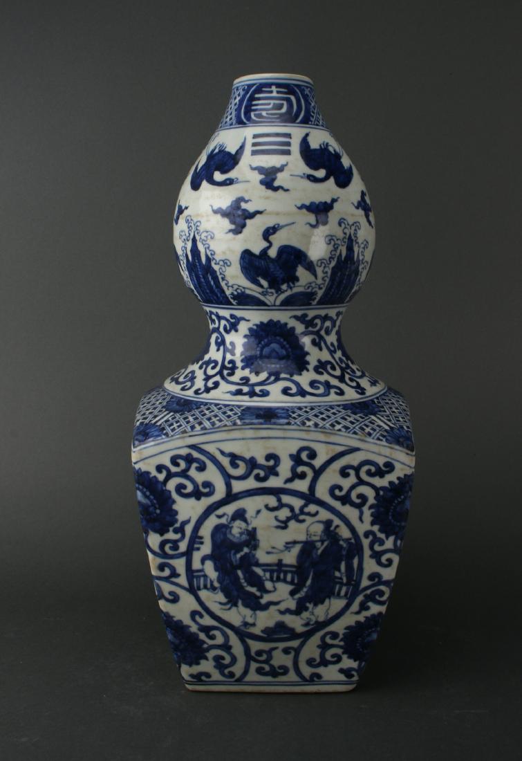 BLUE AND WHITE VASE: Blue And White Vase: A modified double gourd, with the bottom being squared off, in blue and white. The top has cranes, clouds, and i Ching symbols under a diapered border and character patterns. The